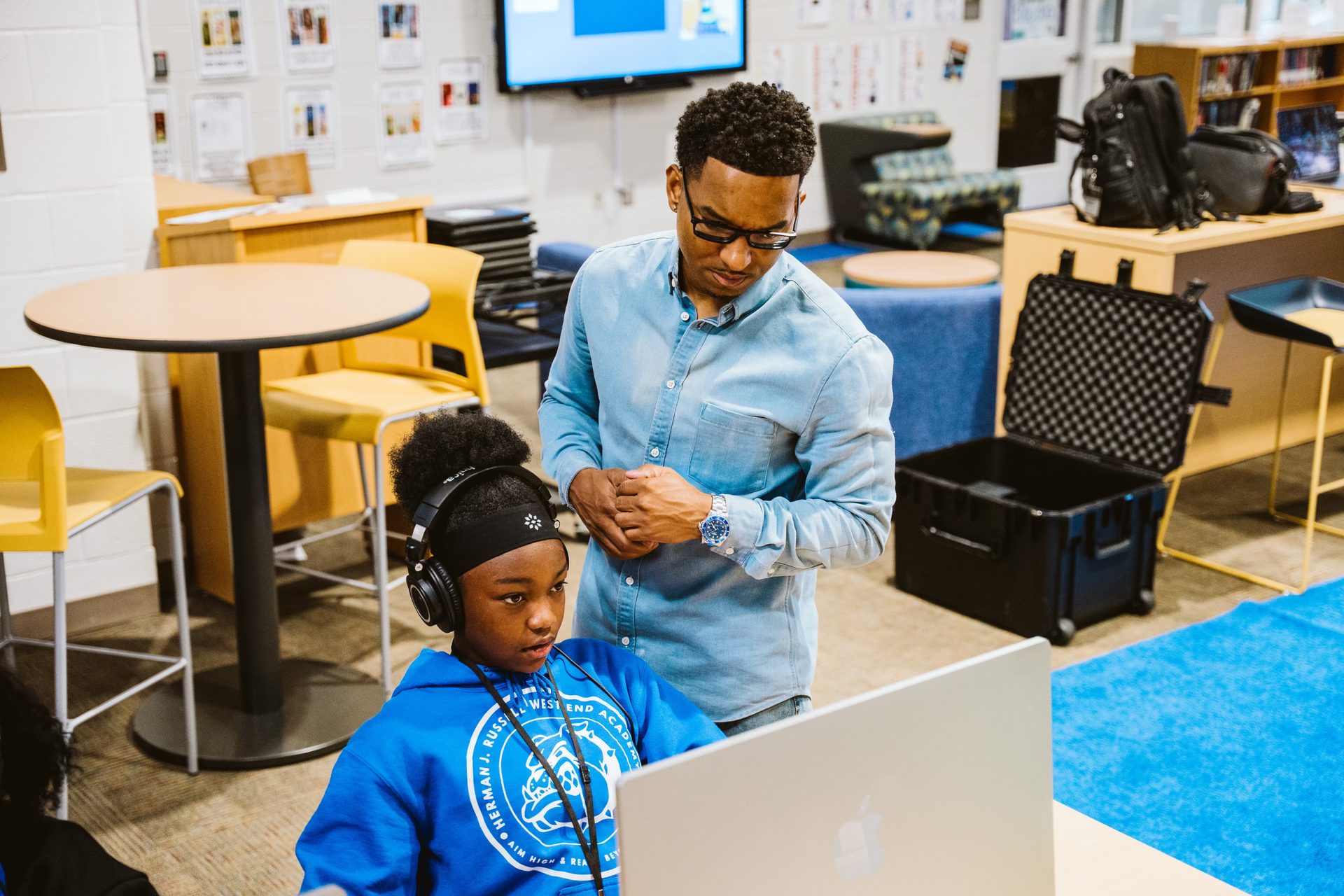 Keyz Bridgez helping a student with headphones